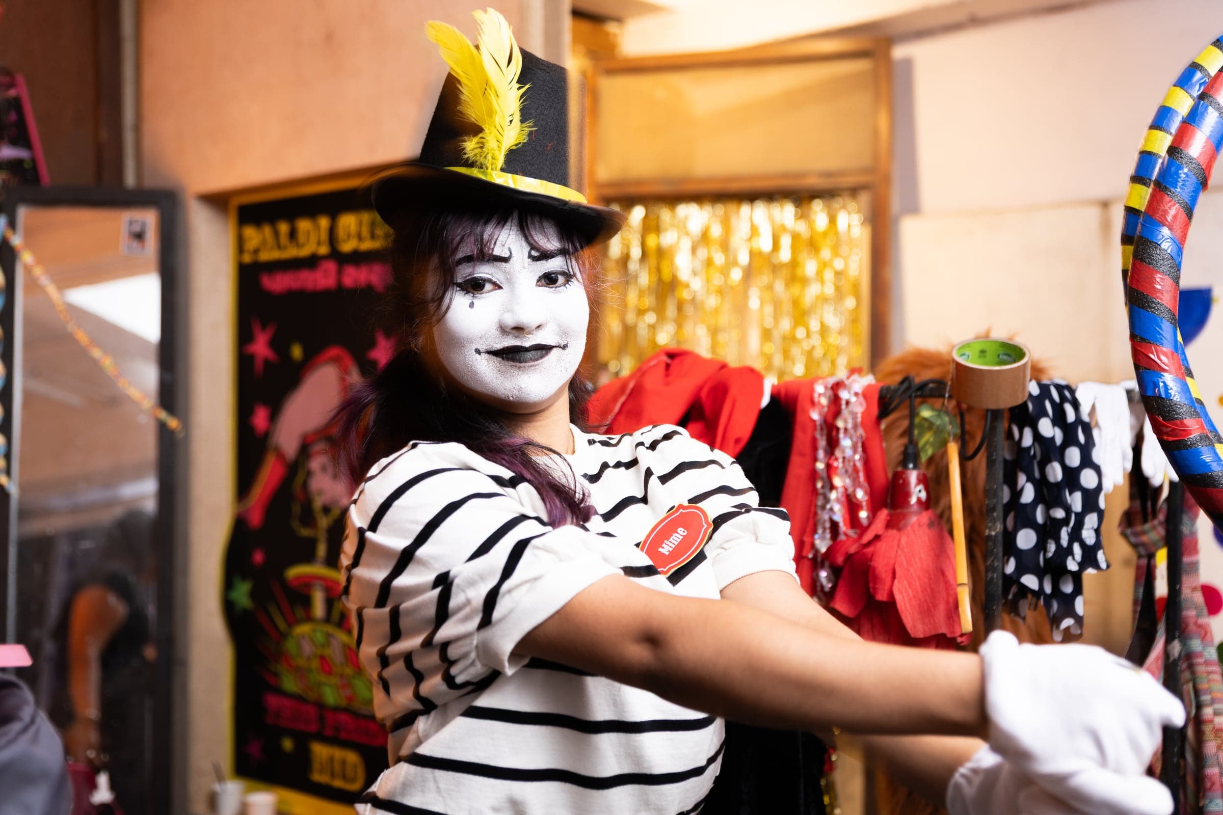 Mime character surrounded by costumes and props