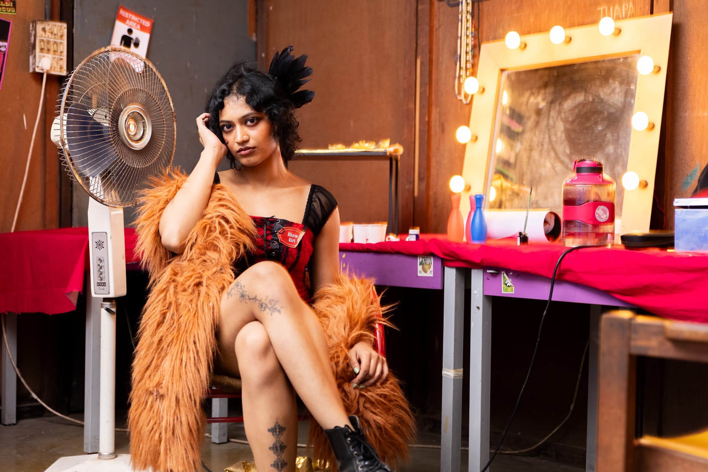 Showgirl character posed inside the dressing-room set