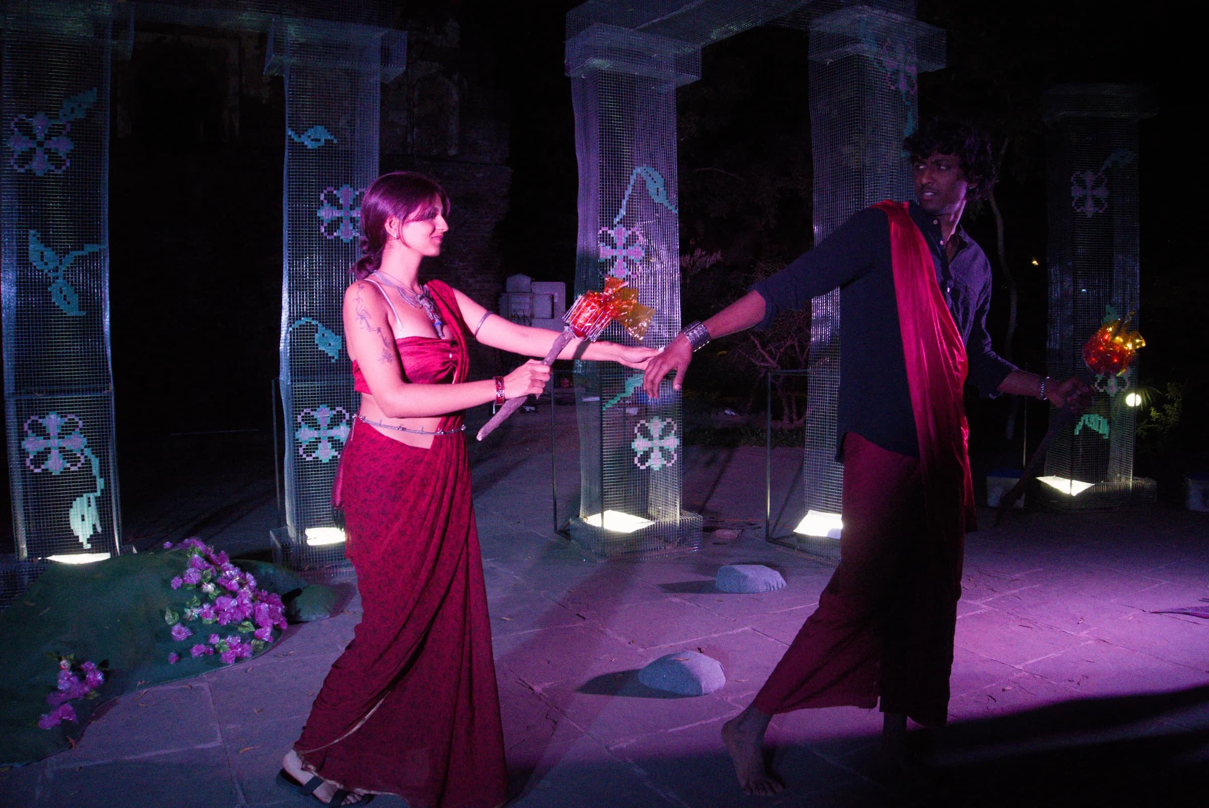 Two performers exchanging a flower prop on stage