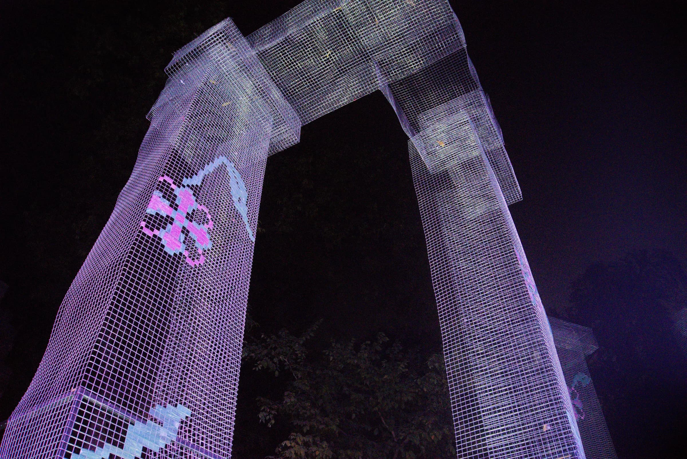 Low-angle detail of translucent mesh columns and floral motifs