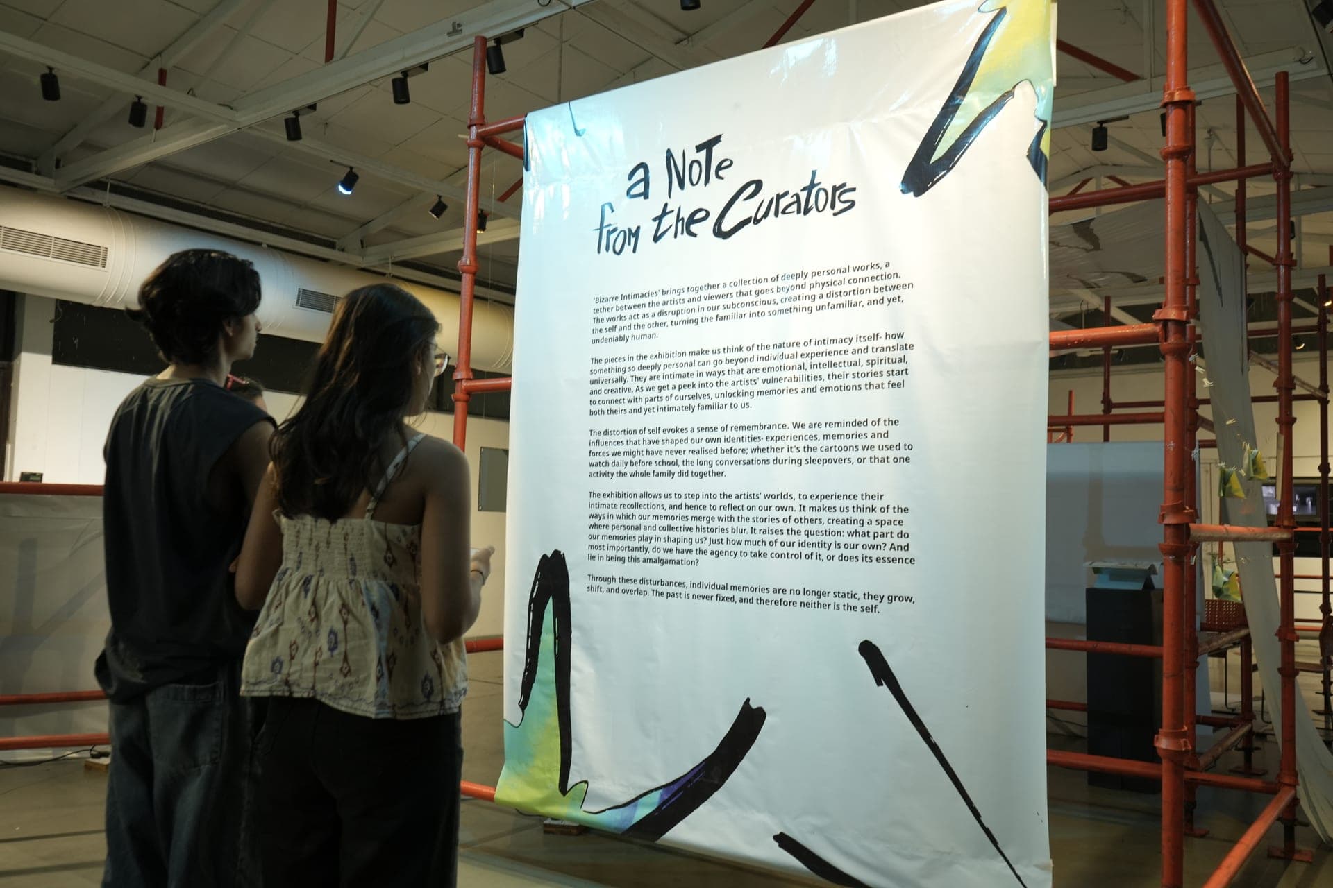 Visitors reading the exhibition text wall