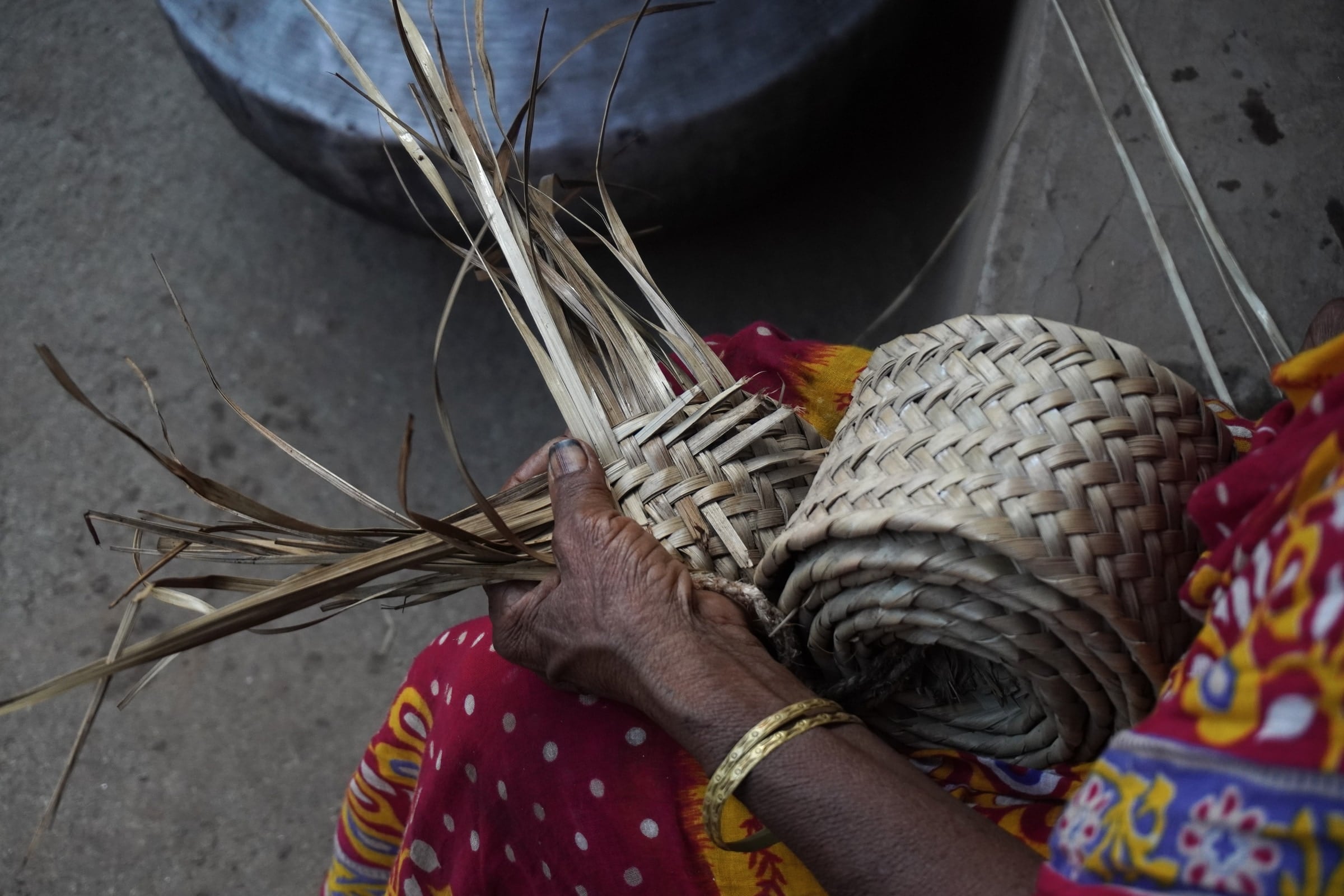 Hands weaving a basket