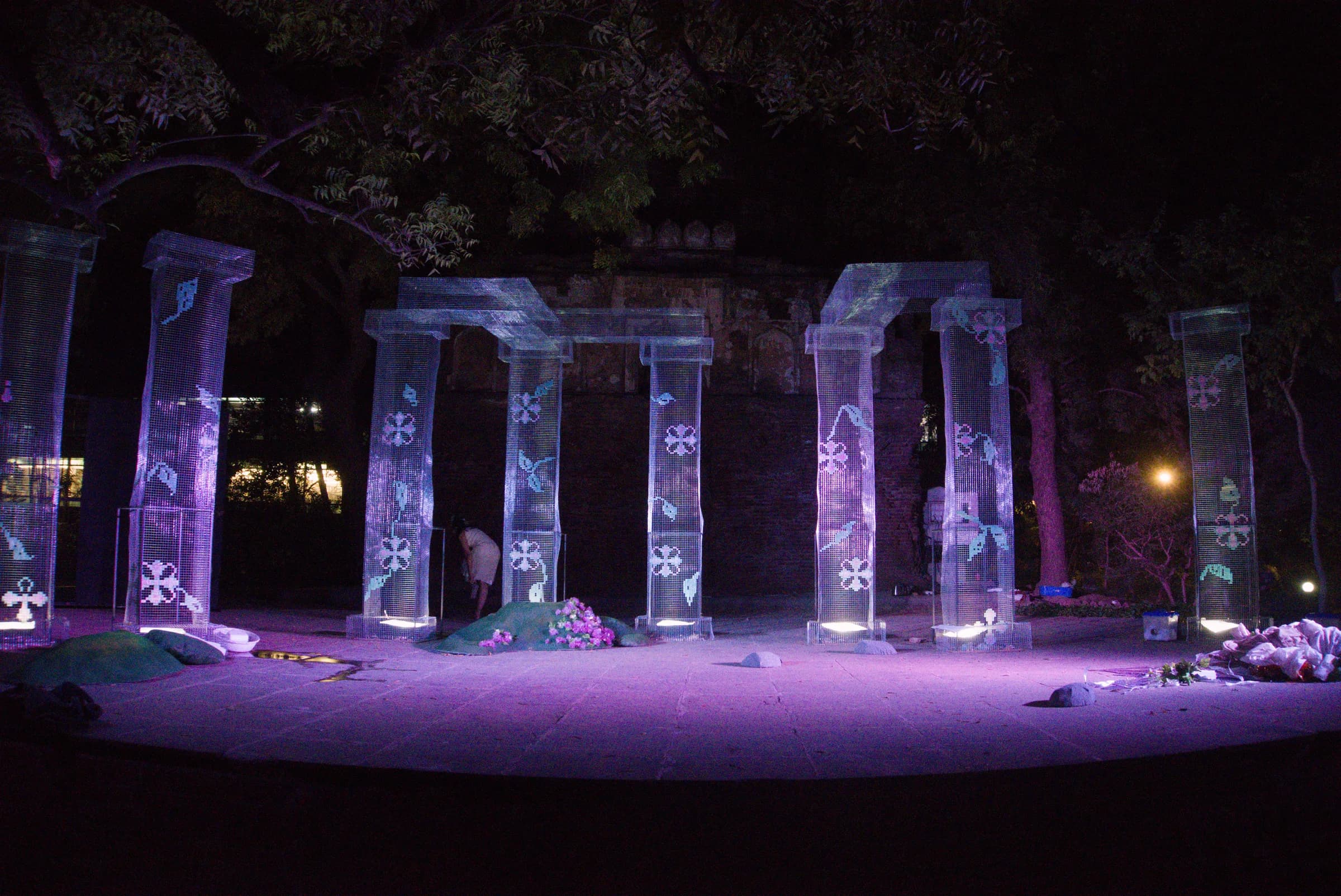 Outdoor stage with translucent columns illuminated in violet light