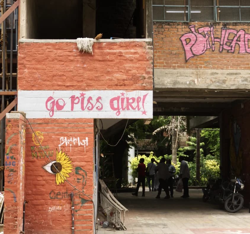 “go piss girl” written on the wall of basketball court